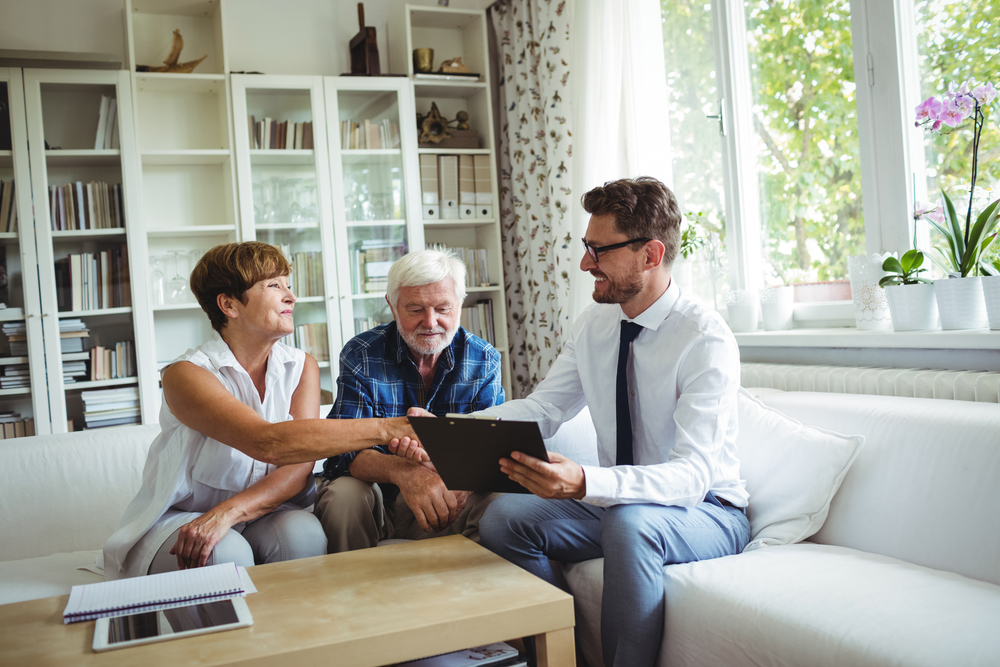 a lawyer helping an older couple with their power of attorney documents