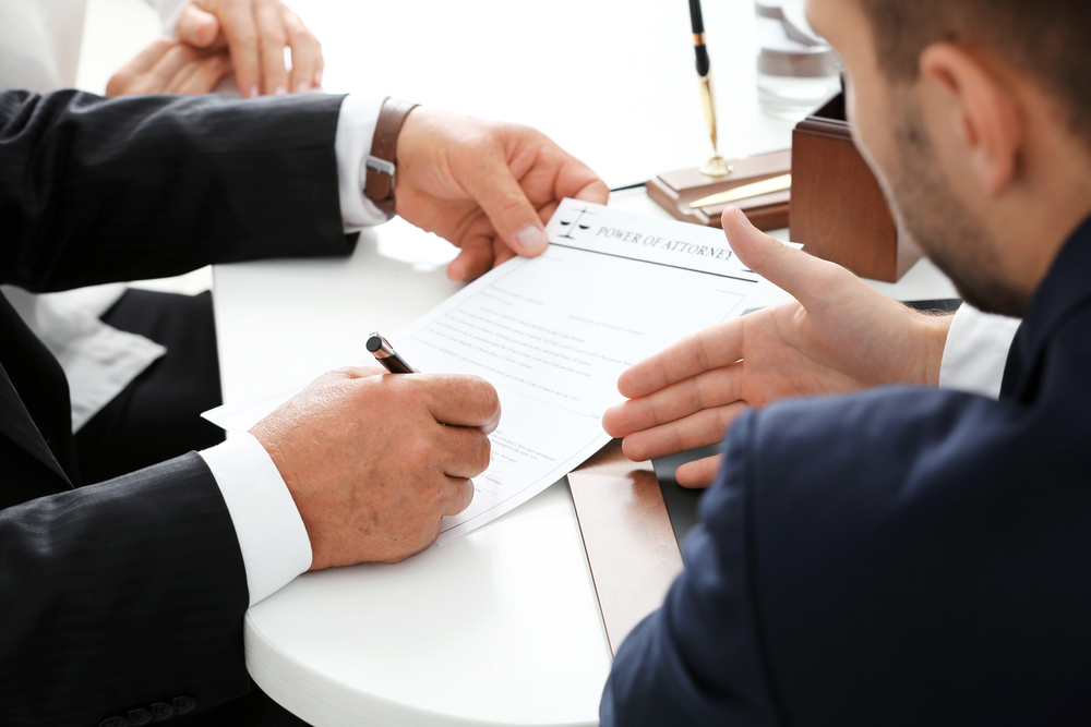 an estate lawyer helping a client finalize their power of attorney