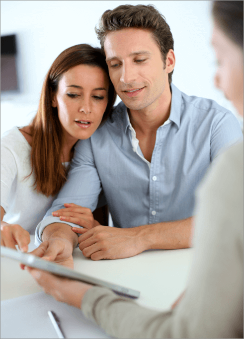 young couple reviewing their Agreement of Purchase of Sale with their real estate lawyer